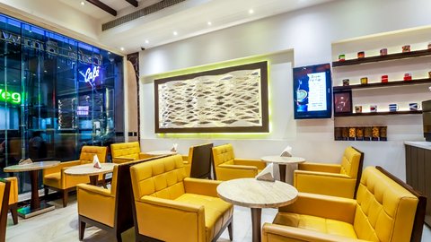 Café Brownie boutique lounge with yellow quilted armchairs and marble tables