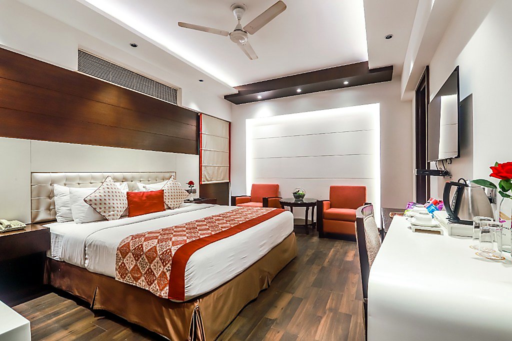 Executive Room at Hotel Grand Godwin New Delhi — king double bed, backlit accent wall, executive workstation, and lounge seating